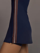 Model wearing a navy blue dress with white and brown stripes