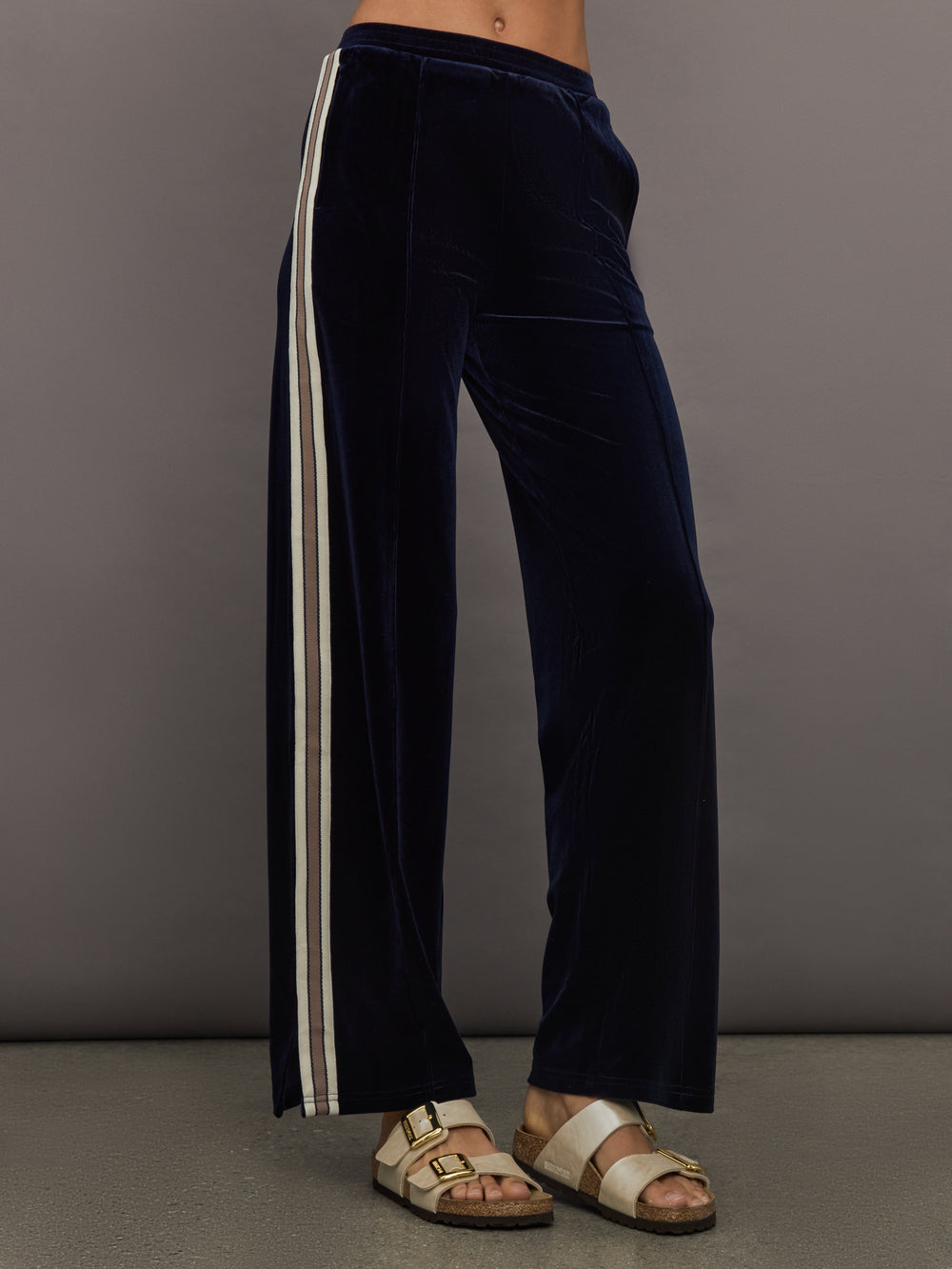Model wearing Navy velvet pants with white stripes
