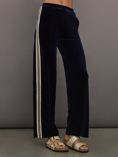 Model wearing Navy velvet pants with white stripes