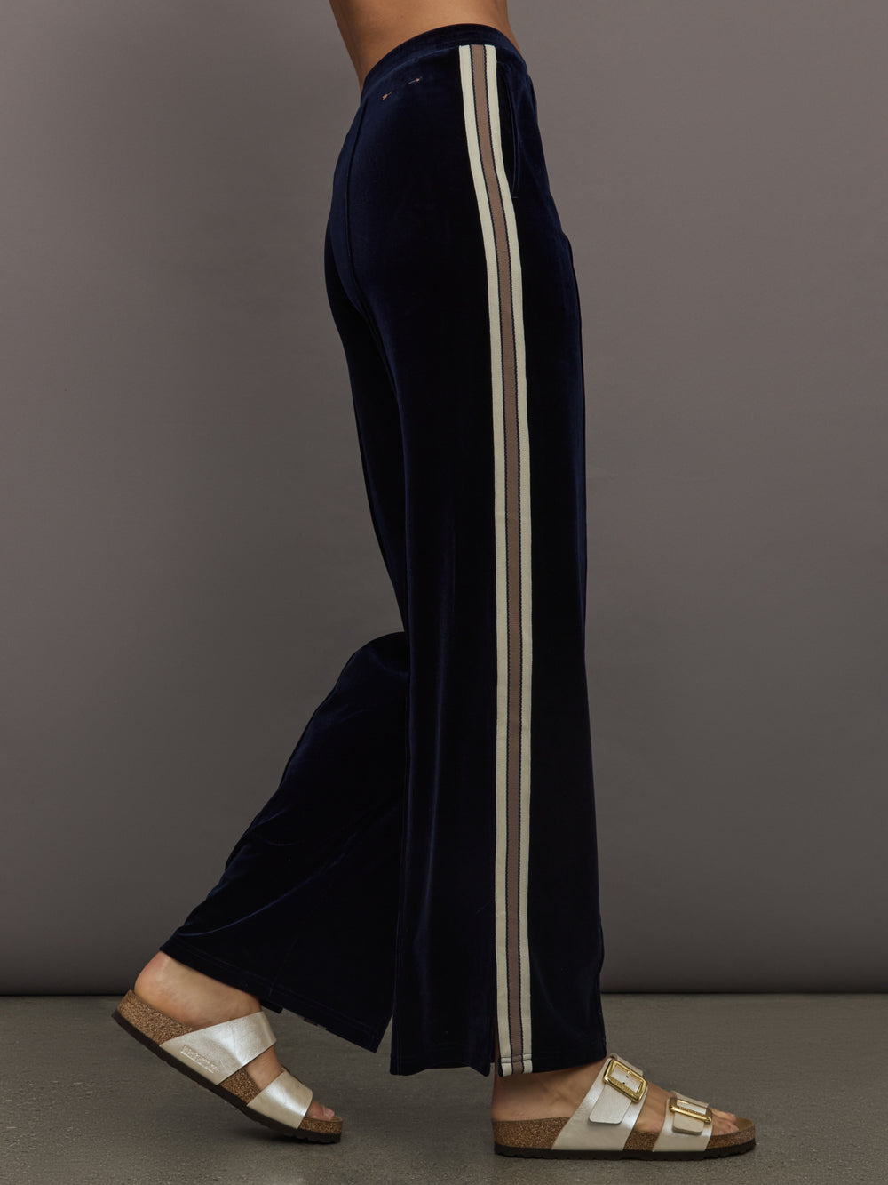 Model wearing Navy velvet pants with white stripes