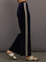 Model wearing Navy velvet pants with white stripes