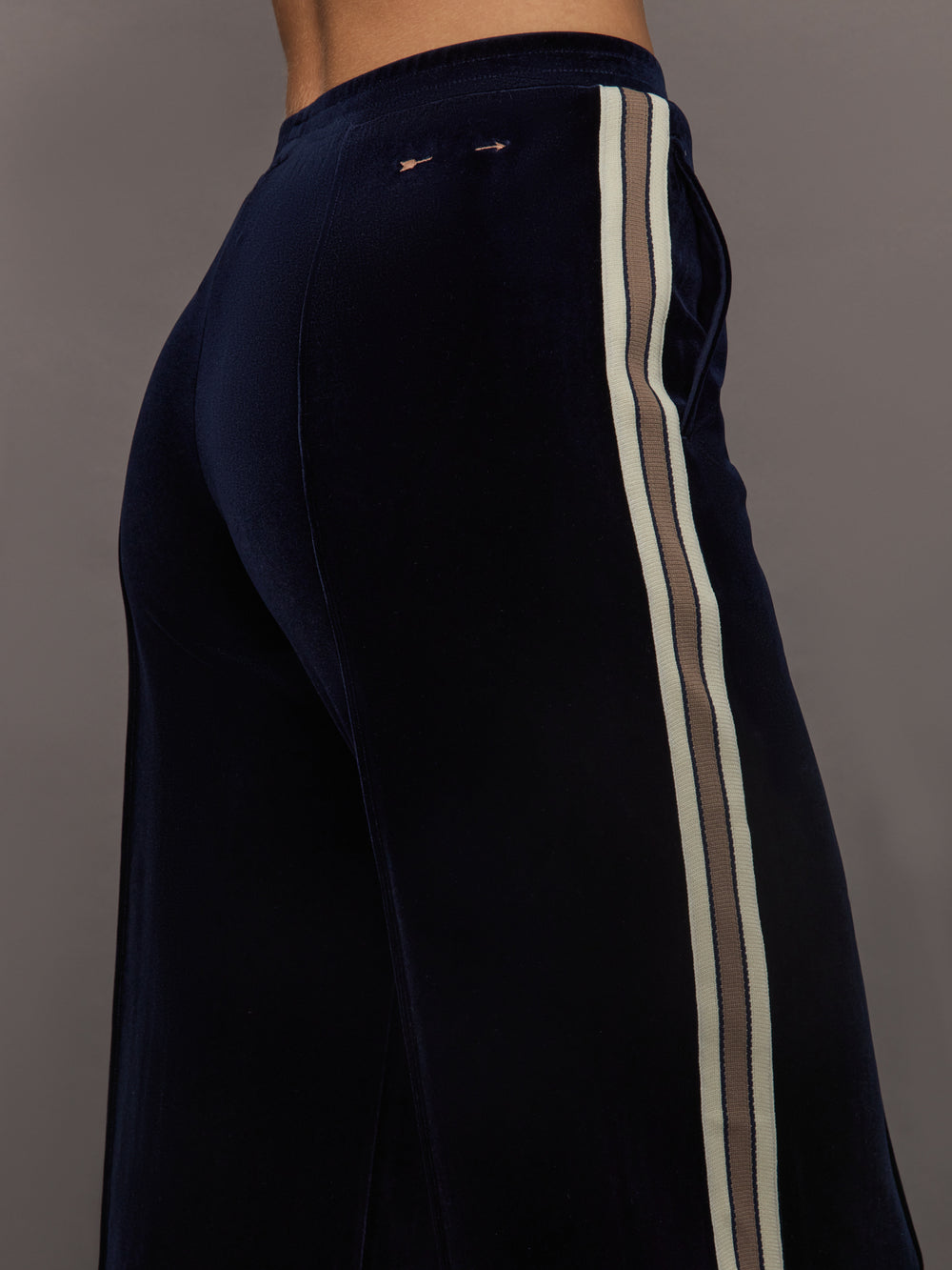 Model wearing Navy velvet pants with white stripes