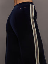 Model wearing Navy velvet pants with white stripes