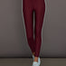 Model wears a pair of high rise burgundy leggings with contrast stripe down side. 