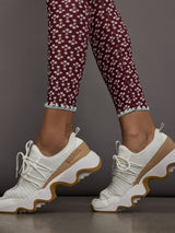 Model wears a high rise pair of red floral leggings. 