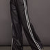 Model wears a pair of dark brown vegan leather track pants with white stipes down side. 