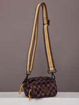 Model wearing brown and black checkered crossbody bag.
