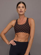Woman wearing a checkered black and brown sports bra.
