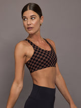 Woman wearing a checkered black and brown sports bra.