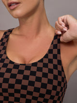 Woman wearing a checkered black and brown sports bra.
