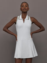 Model wears white sleeveless dress with a fitted bodice and flared skirt, and a collared neck.




