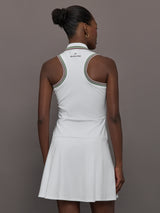 Model wears white sleeveless dress with a fitted bodice and flared skirt, and a collared neck.
