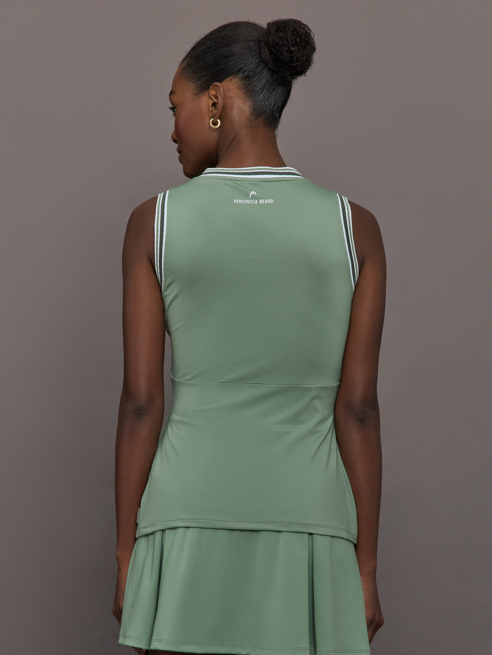 Model wears sage green tank top with a v-neckline and a fitted design.
