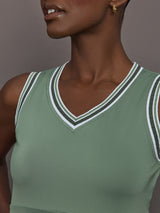 Model wears sage green tank top with a v-neckline and a fitted design.