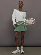 Model wears sage green tank top with a v-neckline and a fitted design.