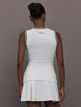 Model wears white tank top with a v-neckline and a fitted design.