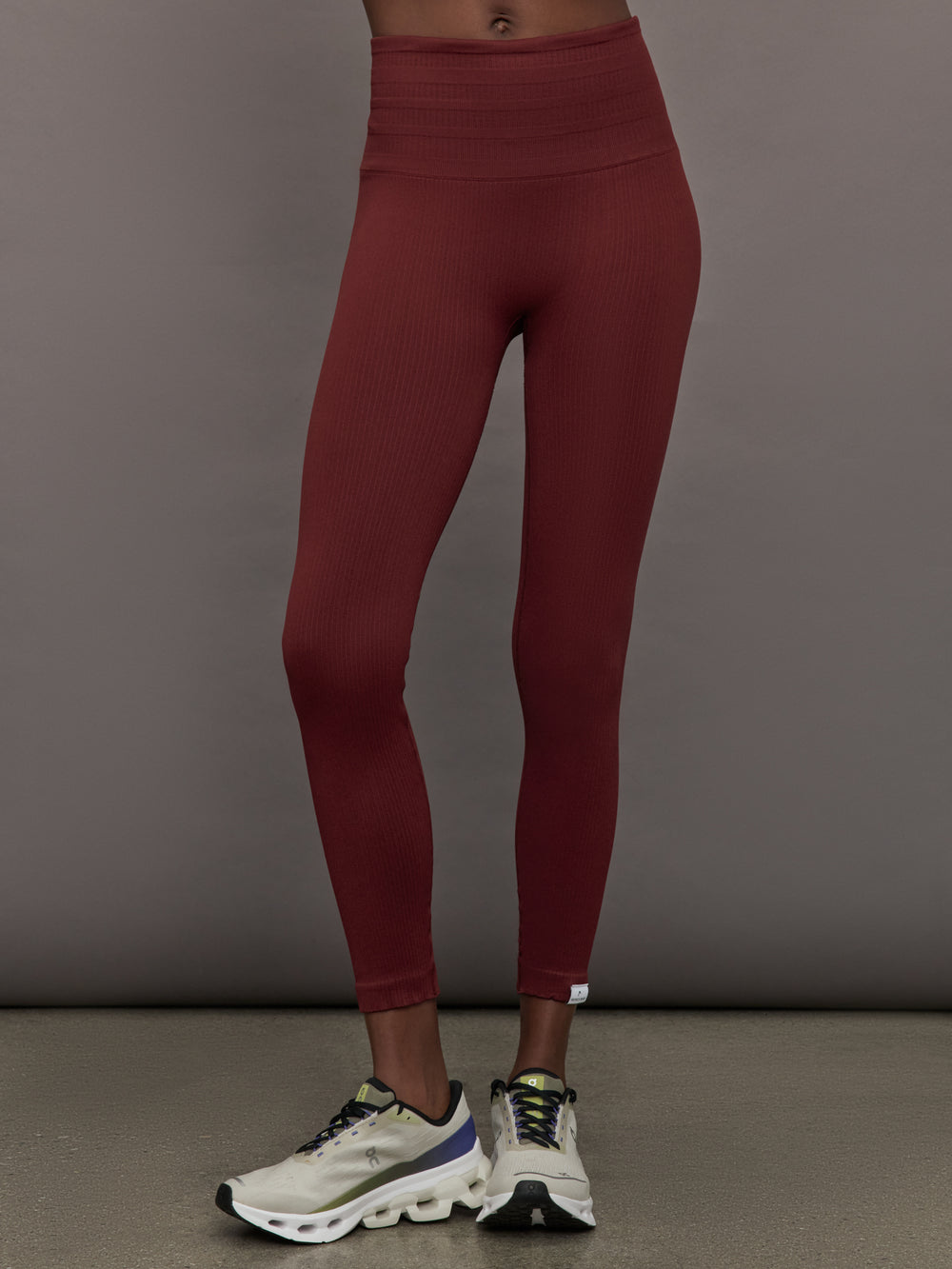 Model wears leggings in Terracotta with a waistband that sits just below the bellybutton and a length that ends slightly above the ankles.




