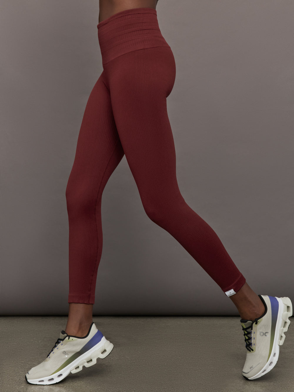 Model wears leggings in Terracotta with a waistband that sits just below the bellybutton and a length that ends slightly above the ankles.
