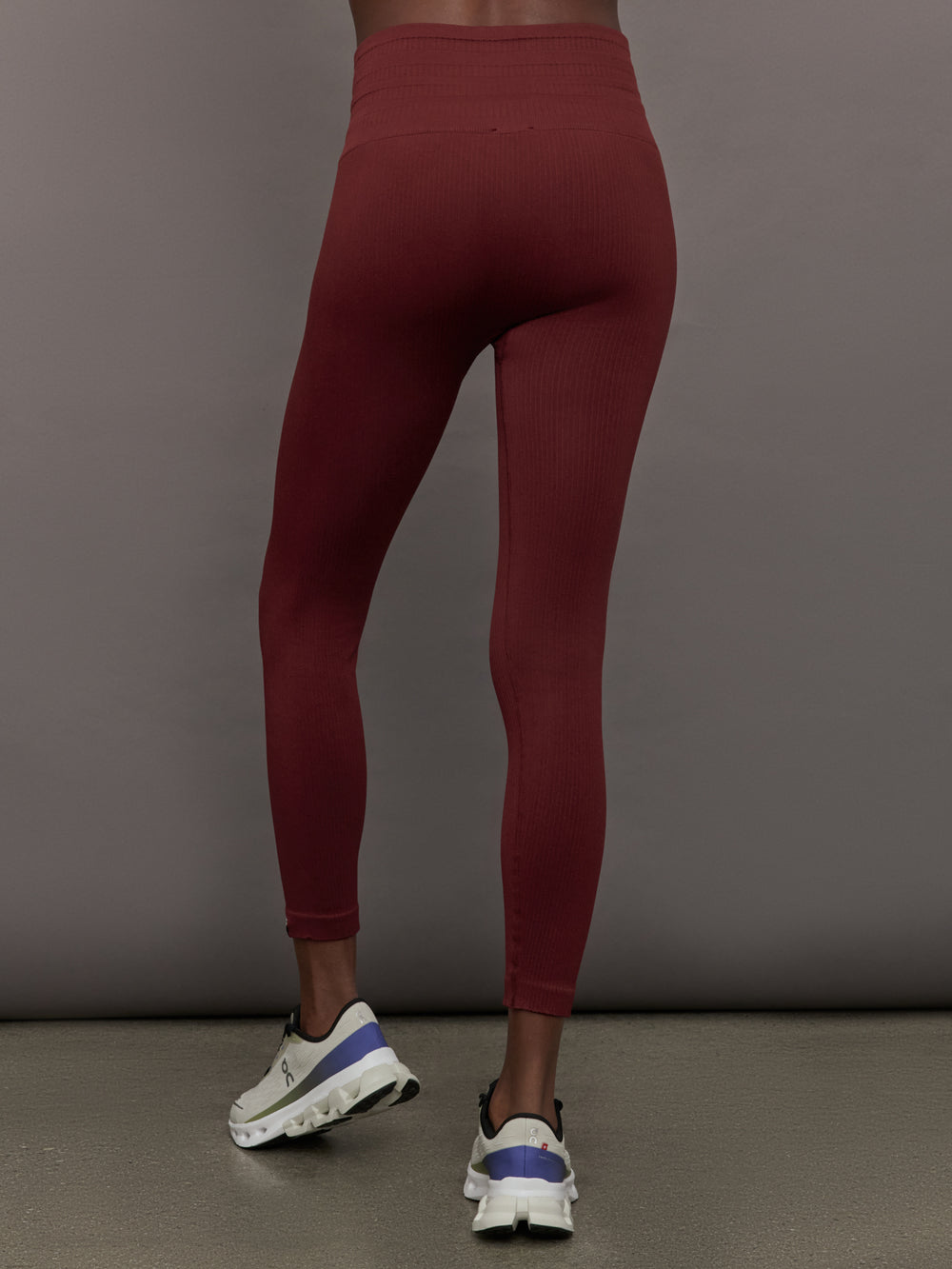 Model wears leggings in Terracotta with a waistband that sits just below the bellybutton and a length that ends slightly above the ankles.
