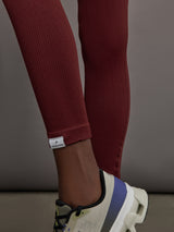 Model wears leggings in Terracotta with a waistband that sits just below the bellybutton and a length that ends slightly above the ankles.
