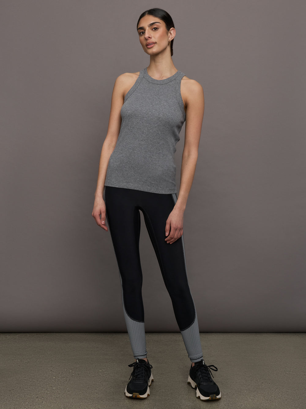 Model wears a heather gray high neck tank top. 