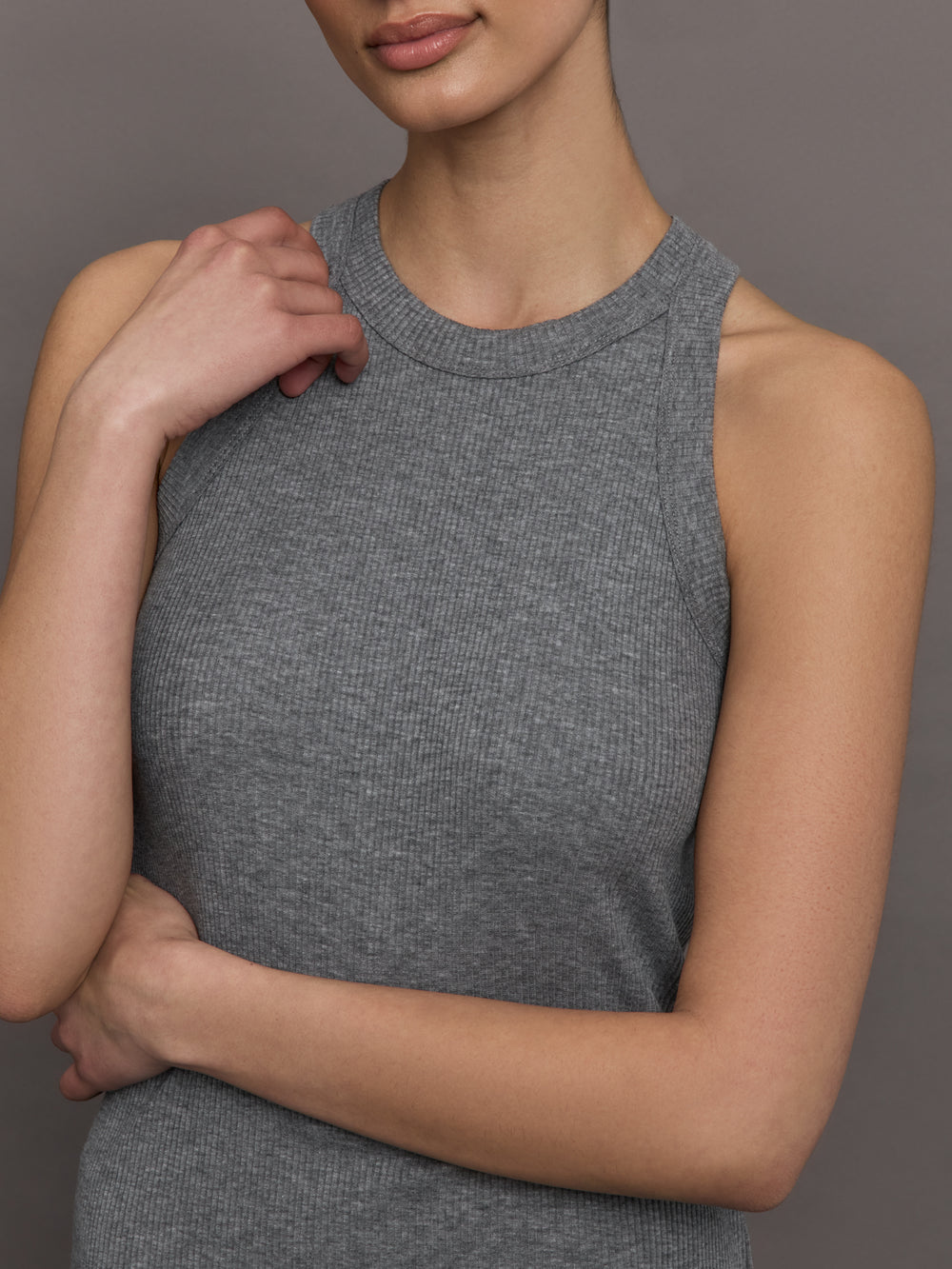 Model wears a heather gray high neck tank top. 