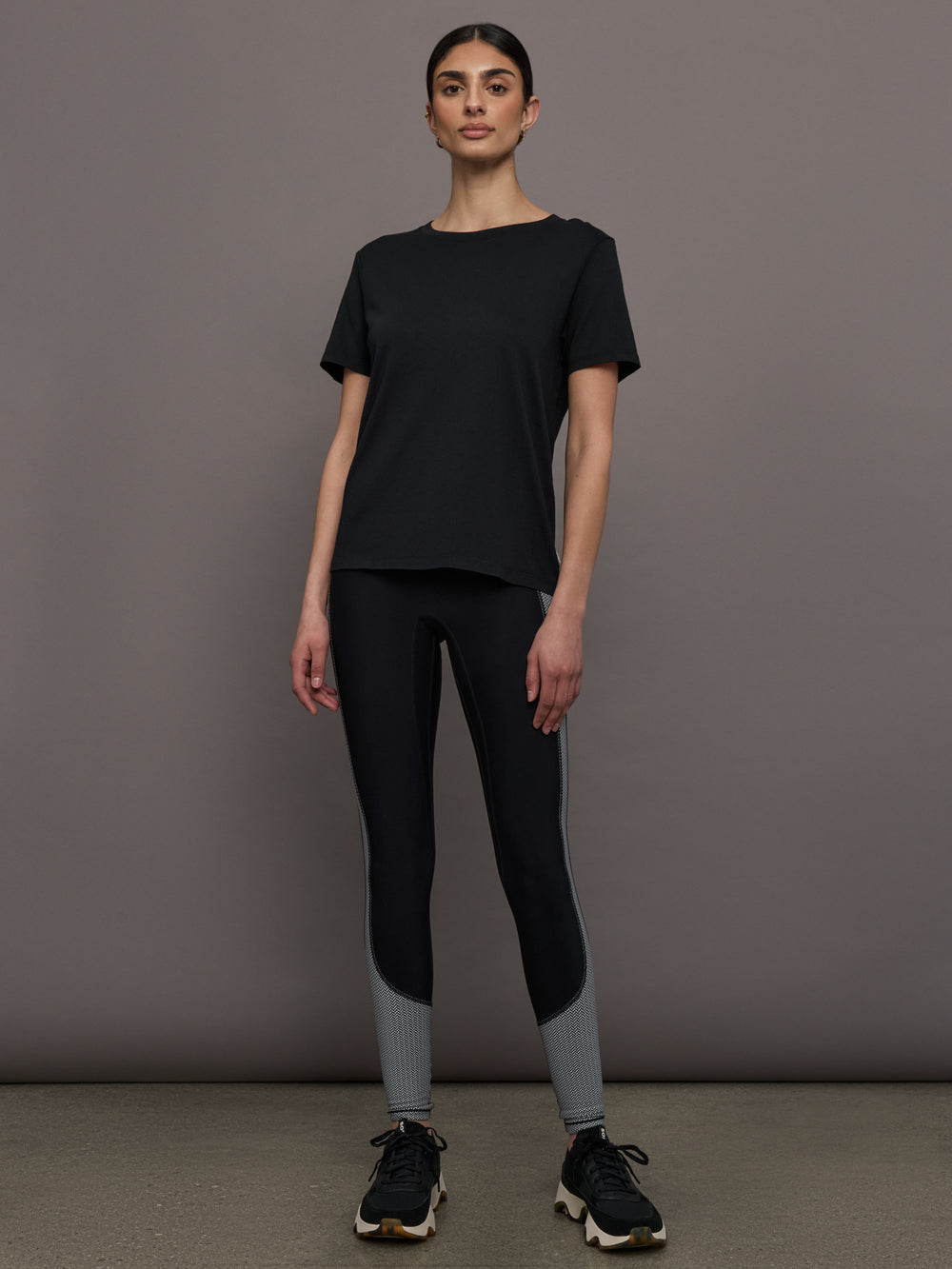 Model wears an oversized classic black tee shirt. 