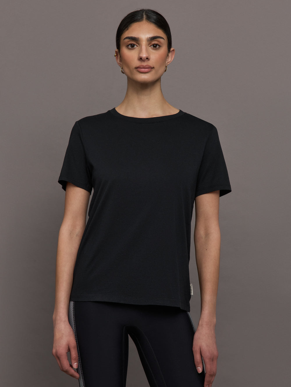 Model wears an oversized classic black tee shirt. 