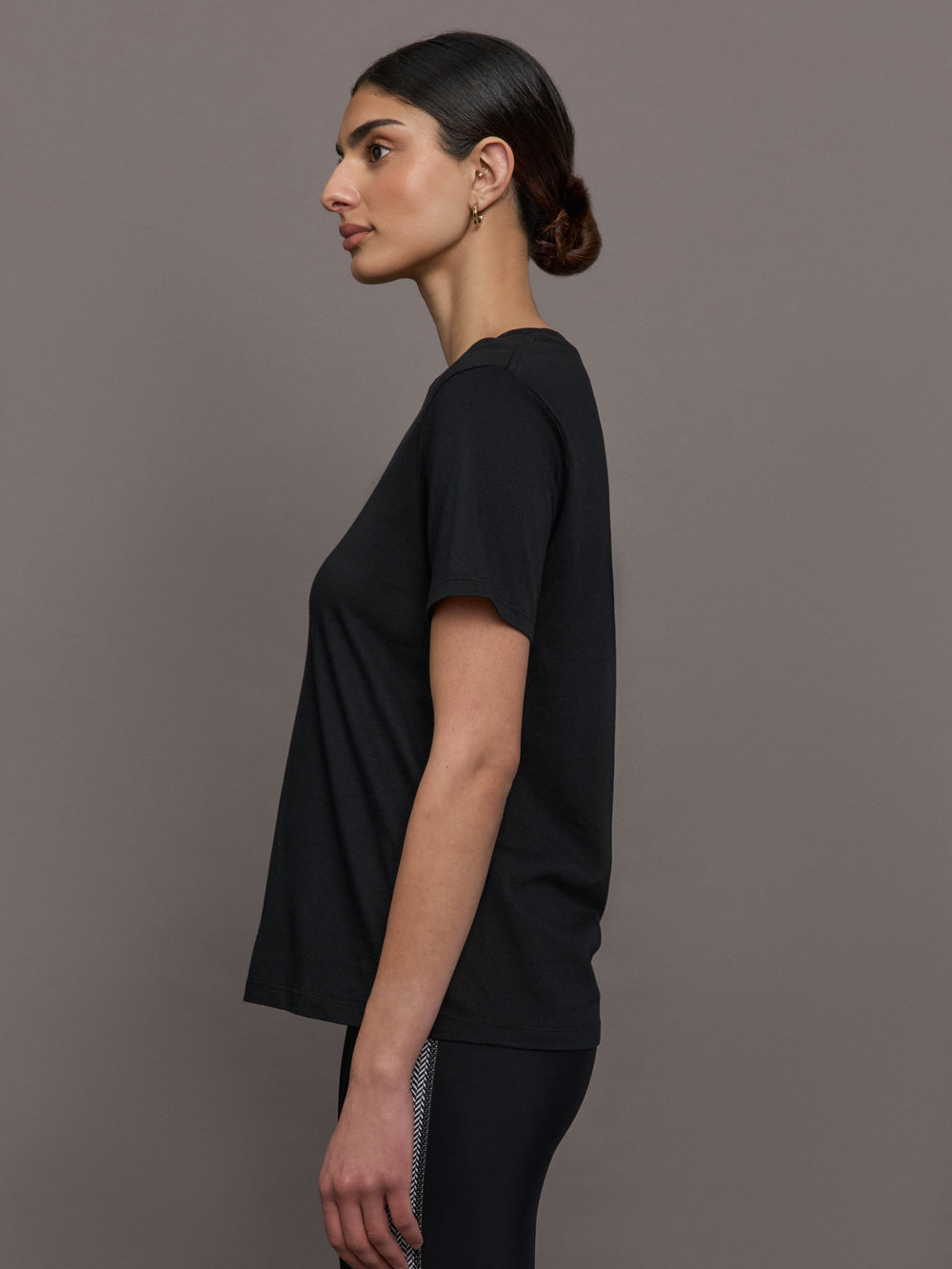 Model wears an oversized classic black tee shirt. 