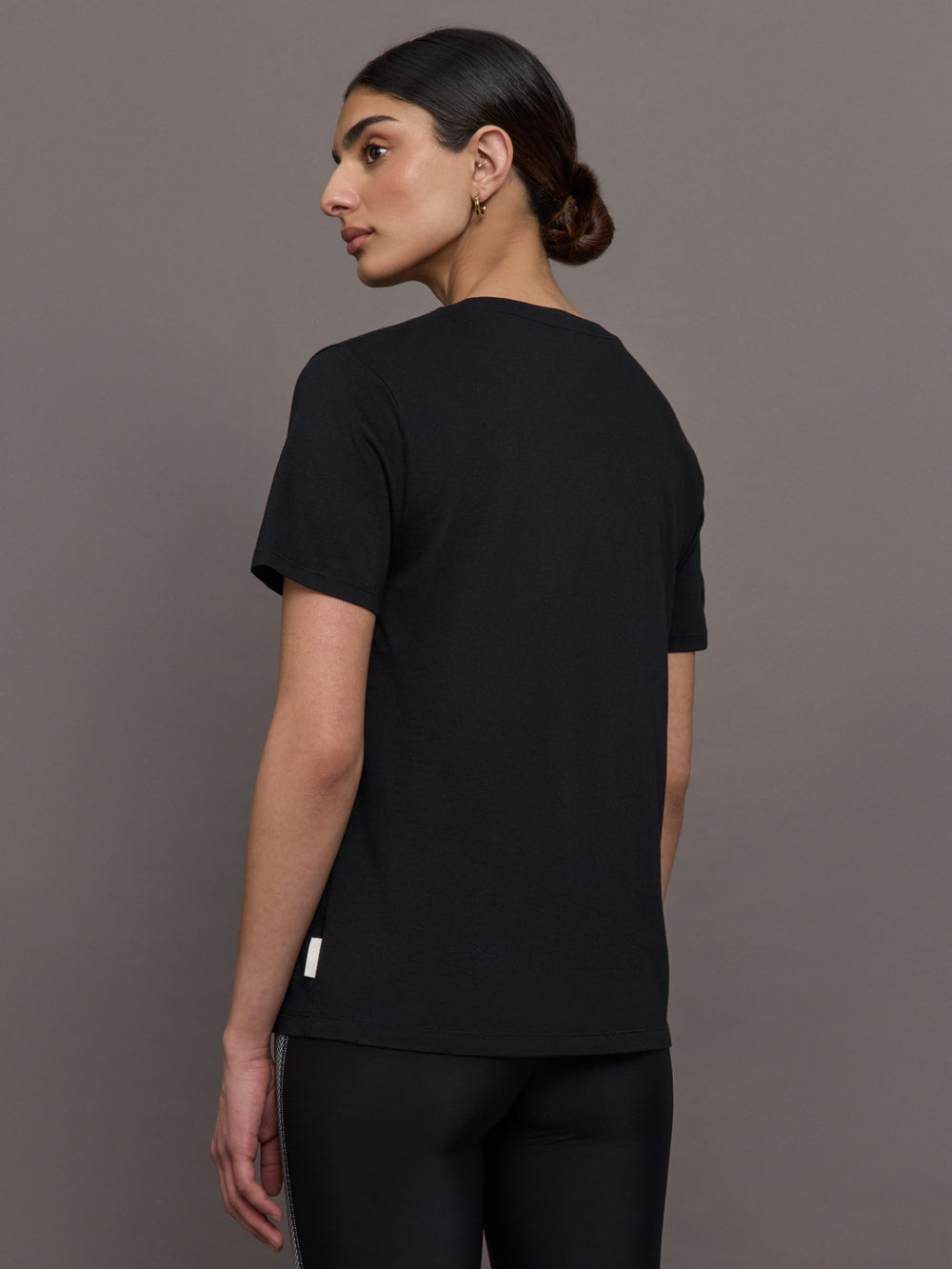 Model wears an oversized classic black tee shirt. 