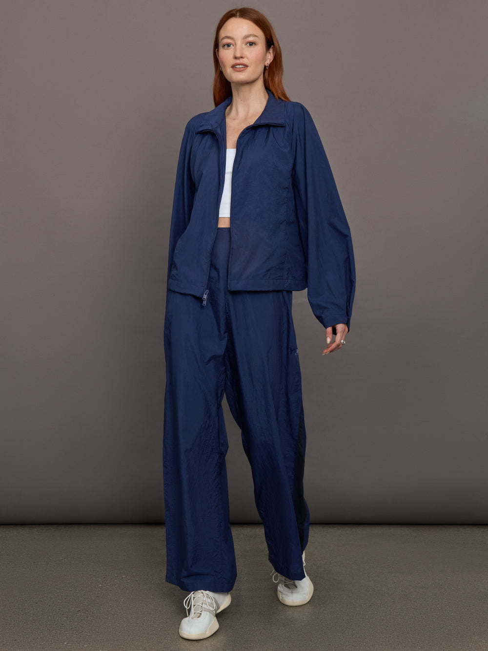 Model wears the Ulite nylon jacket in dark blue with a front zipper closure and relaxed fit.