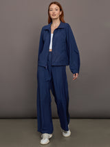 Model wears the Ulite nylon jacket in dark blue with a front zipper closure and relaxed fit.