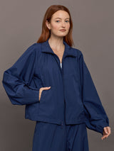 Model wears the Ulite nylon jacket in dark blue with a front zipper closure and relaxed fit.