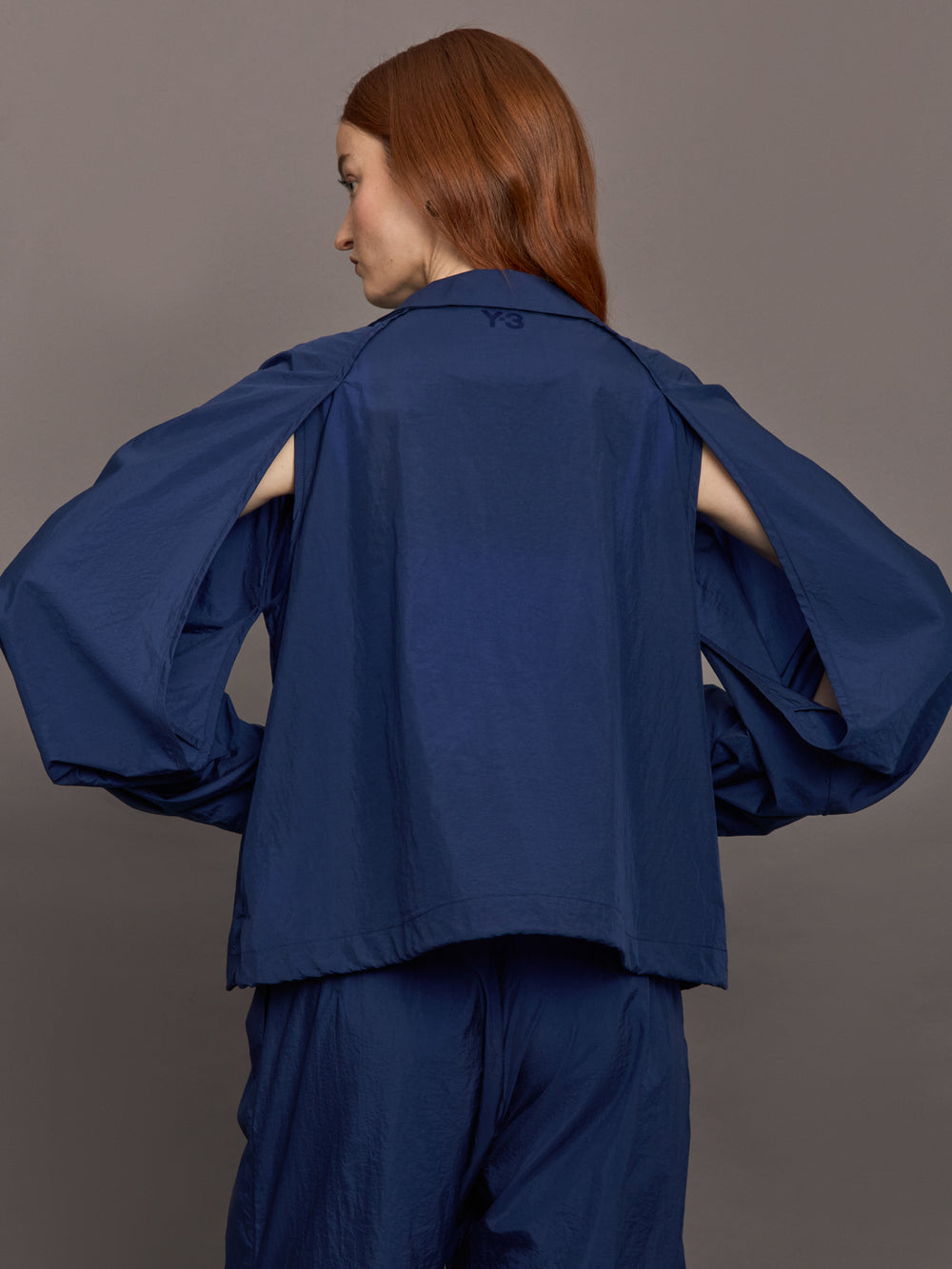 Model wears the Ulite nylon jacket in dark blue with a front zipper closure and relaxed fit.