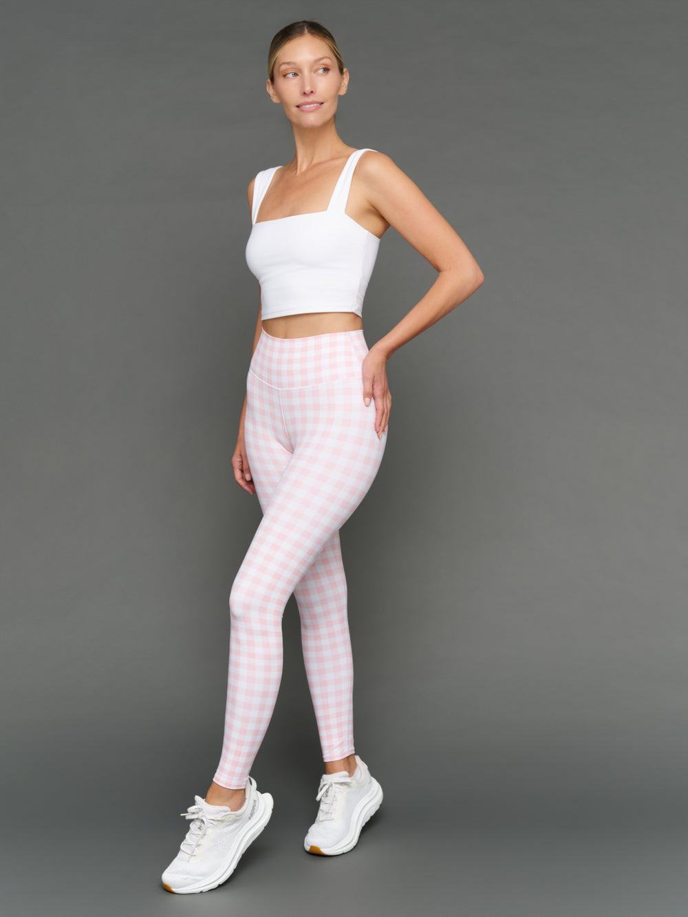 Model wears Gingham Leggings and a white sports bra on a grey background