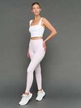 Model wears Gingham Leggings and a white sports bra on a grey background