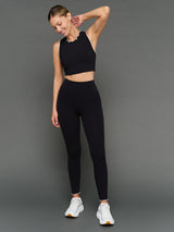 Model is wearing Melt scallop edge cropped bra in black white, styled with leggings full body view.
