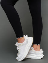 Model is wearing Melt scallop edge legging in black white, ankle scallop detail close-up.