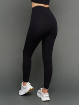Model is wearing Melt scallop edge legging in black white, back full body view.