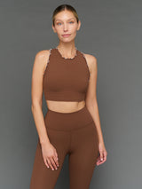 Model is wearing Melt scallop edge cropped bra in carafe white, front view.