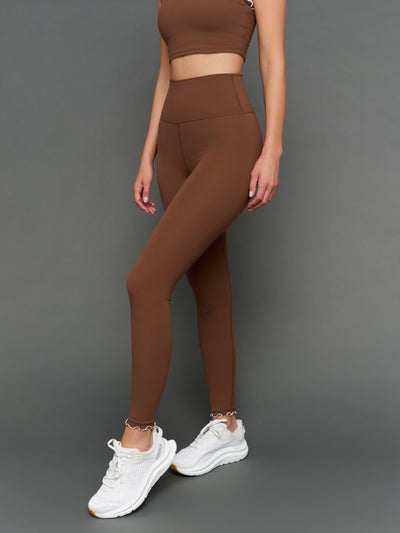 Model is wearing Melt scallop edge legging in carafe white, front full body angled view.
