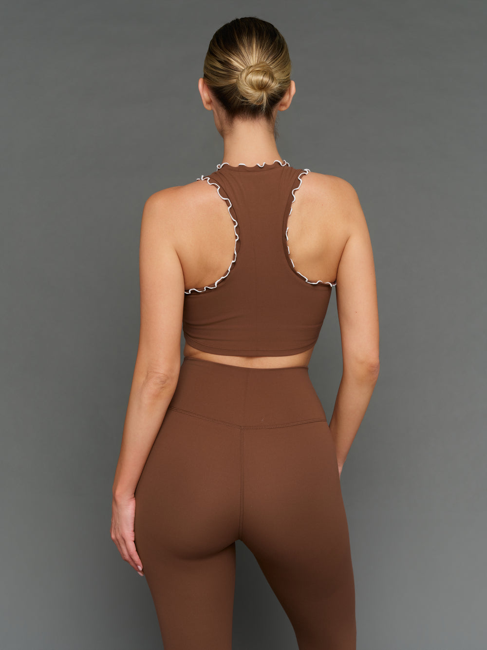 Model is wearing Melt scallop edge cropped bra in carafe white, back view.