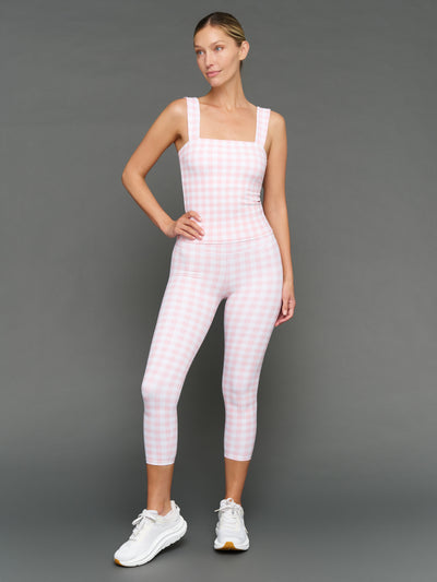 Model wears a pink gingham tank top and capri leggings against a grey background.