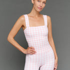 Model wears a pink gingham tank top against a grey background.