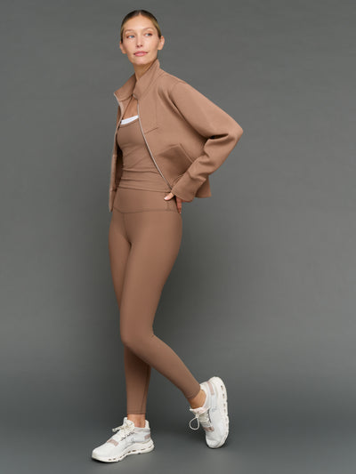 Model is wearing double layer melt tank caribou white with matching leggings and jacket, full body styled look.