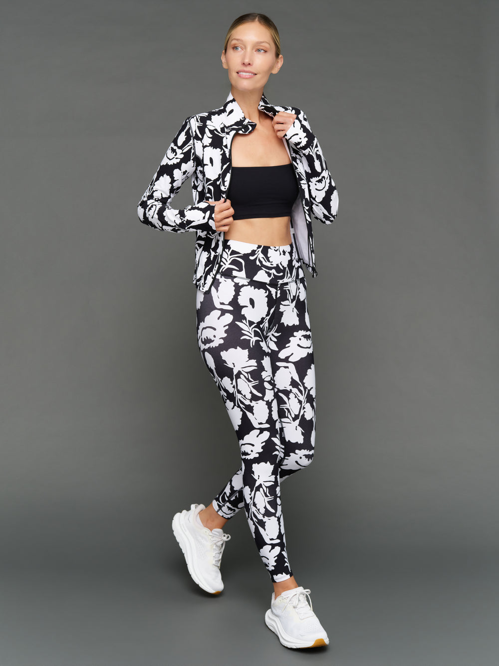Model is wearing melt high-waisted legging floral print styled with jacket, full body view.