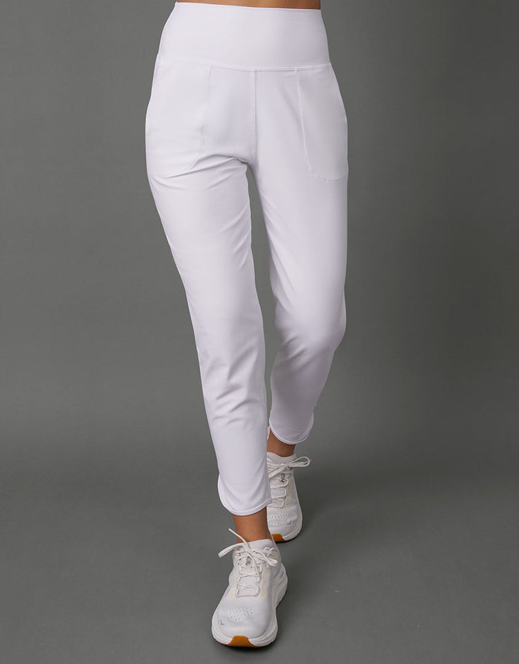 White high-waisted athletic leggings with a side pocket, shown on a model from the waist down against a solid gray studio background.