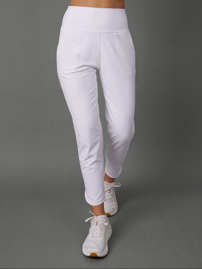 White high-waisted athletic leggings with a side pocket, shown on a model from the waist down against a solid gray studio background.