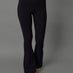 Model wears black bootcut leggings against a grey background