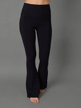 Model wears black bootcut leggings against a grey background